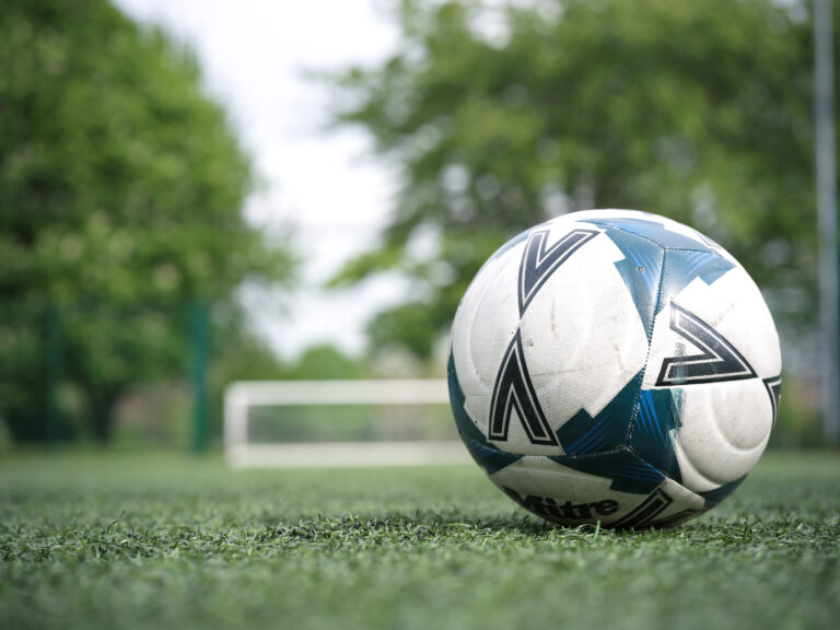 Football resting on an artificial grass pitch
