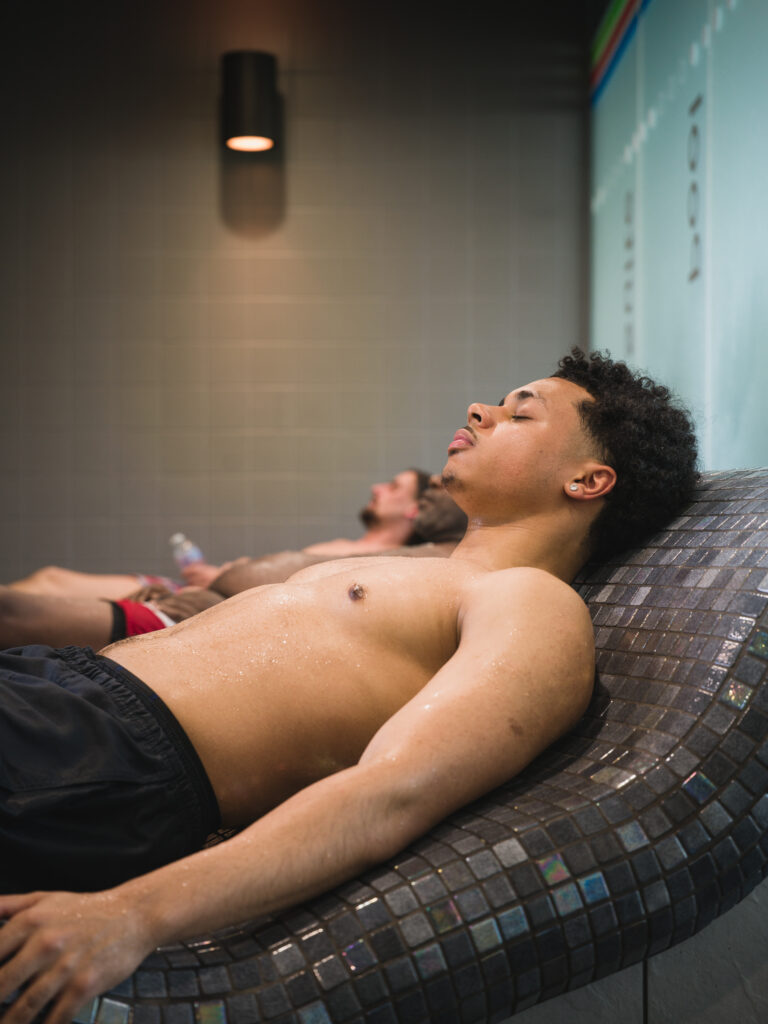 Member relaxing on a heated lounger in the Isleworth spa